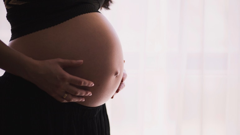 Femme enceinte angoissée touchant son ventre