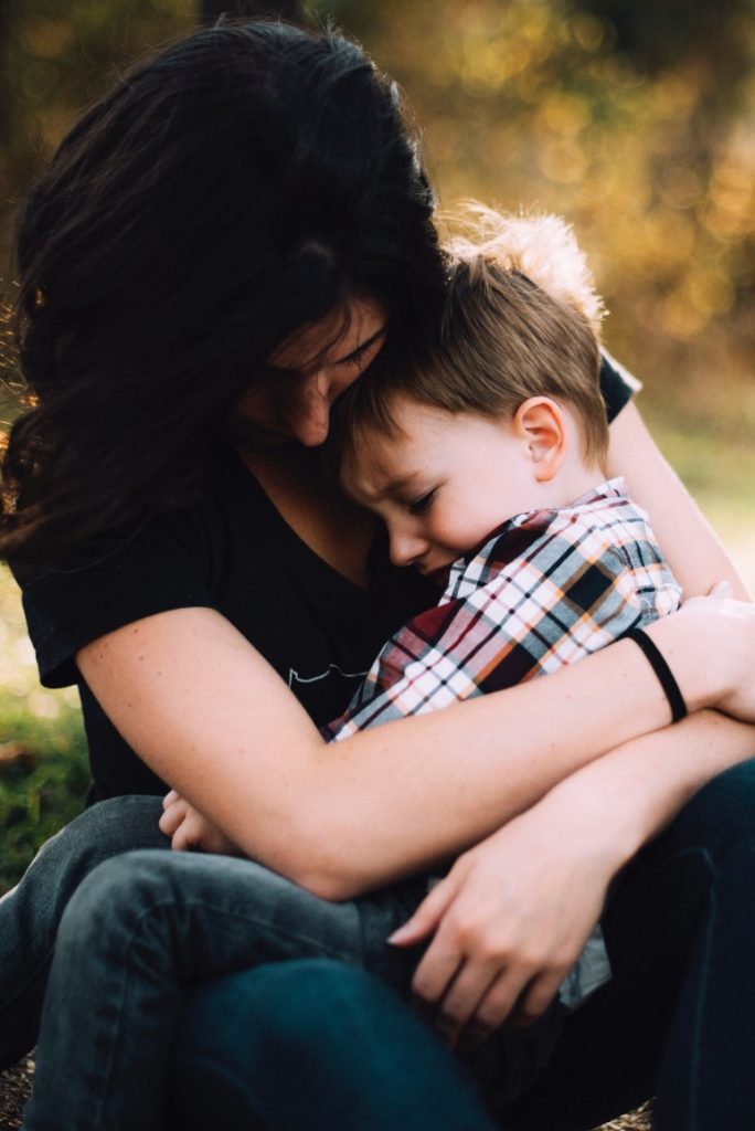 Une maman sert fort son enfant dans ses bras afin de le réconforter après avoir géré une crise 