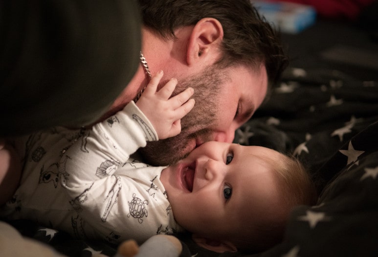 Papa et son bébé qui rigolent pendant un rituel de coucher
