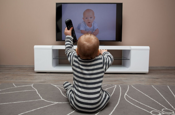 bébé assis de la télévision sur un tapis